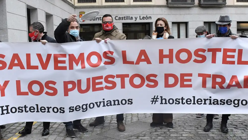 SEGOVIA, 09/02/2021.- Un manifestante arroja un plato mientras miembros de la Asociación de Alojamiento Hostelería y Turismo de Segovia (HOTUSE-AIHS) se concentran este martes delante de la Subdelegación del Gobierno y la Delegación Territorial de la Junta de Castilla y León en Segovia dentro de las protestas convocadas en varias ciudades de España contra las restricciones impuestas al sector con motivo de la pandemia de covid-19 y para reclamar ayudas económicas. EFE/Pablo Martín