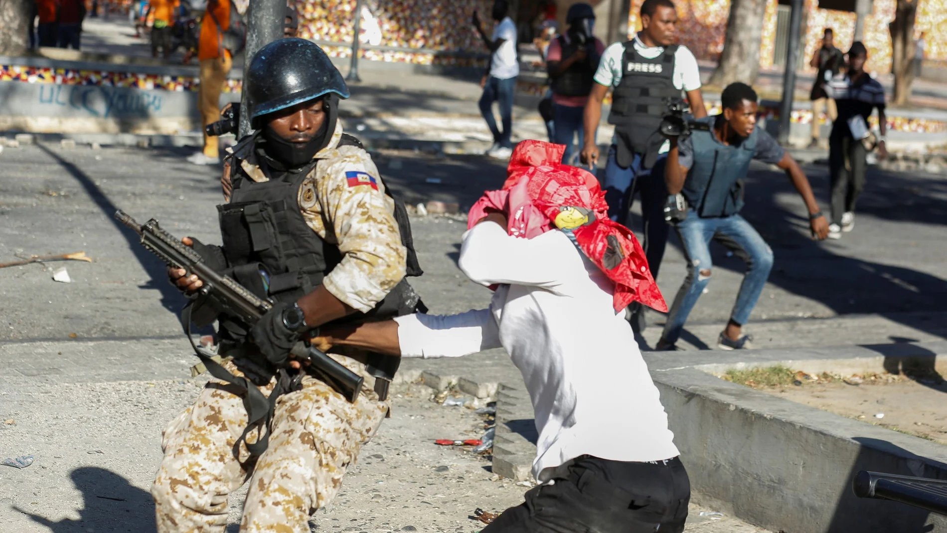 Un manifestante intenta agarrar el rifle de un oficial de policía durante las protestas contra el presidente de Haití, Jovenel Moise, en Puerto Príncipe