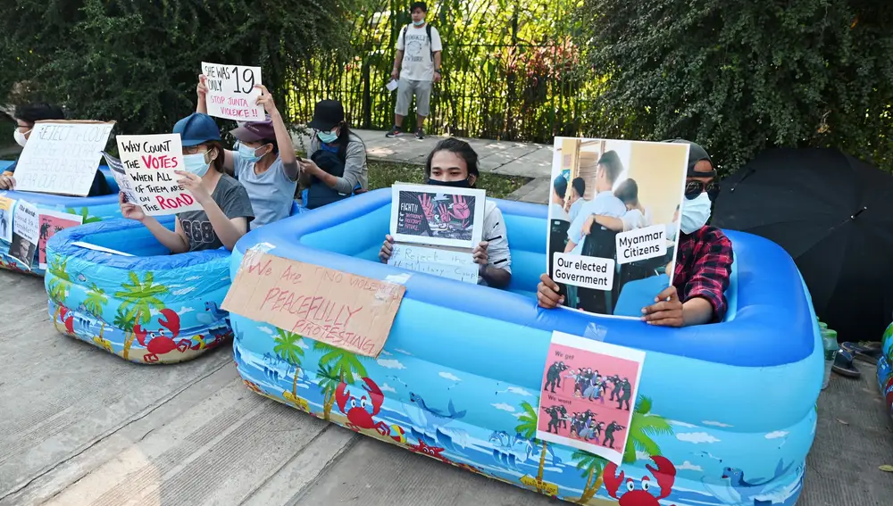 Un grupo de personas protesta frente a la embajada de Japón en Yangon, con piscinas de plástico