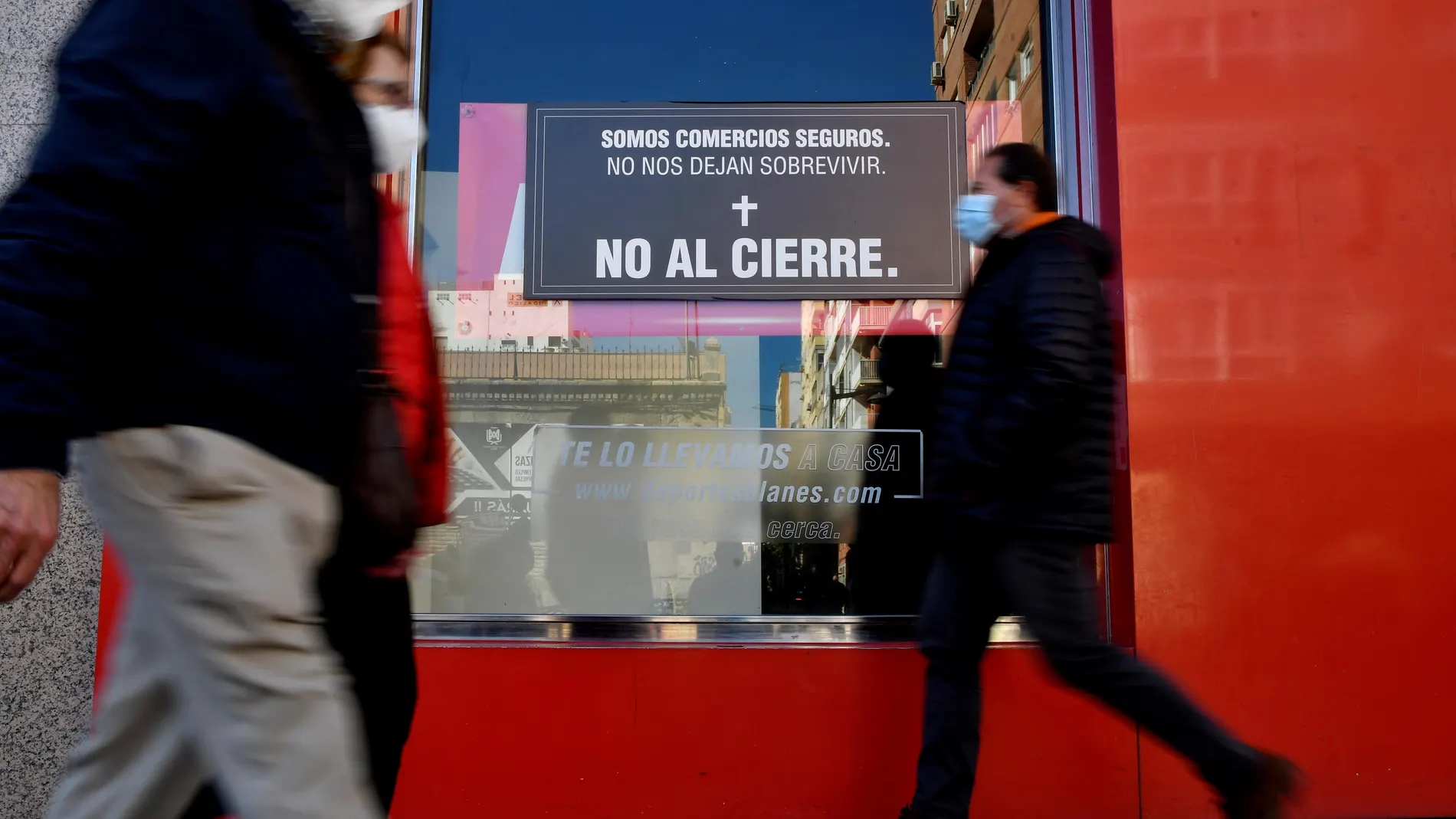 Un escaparate de un comercio del centro de Almería muestra unos carteles en protesta por la situación en la que se encuentran debido al cierre de los establecimientos no esenciales provocado por la tasa de contagios de la Covid-19 en la ciudad de Almería