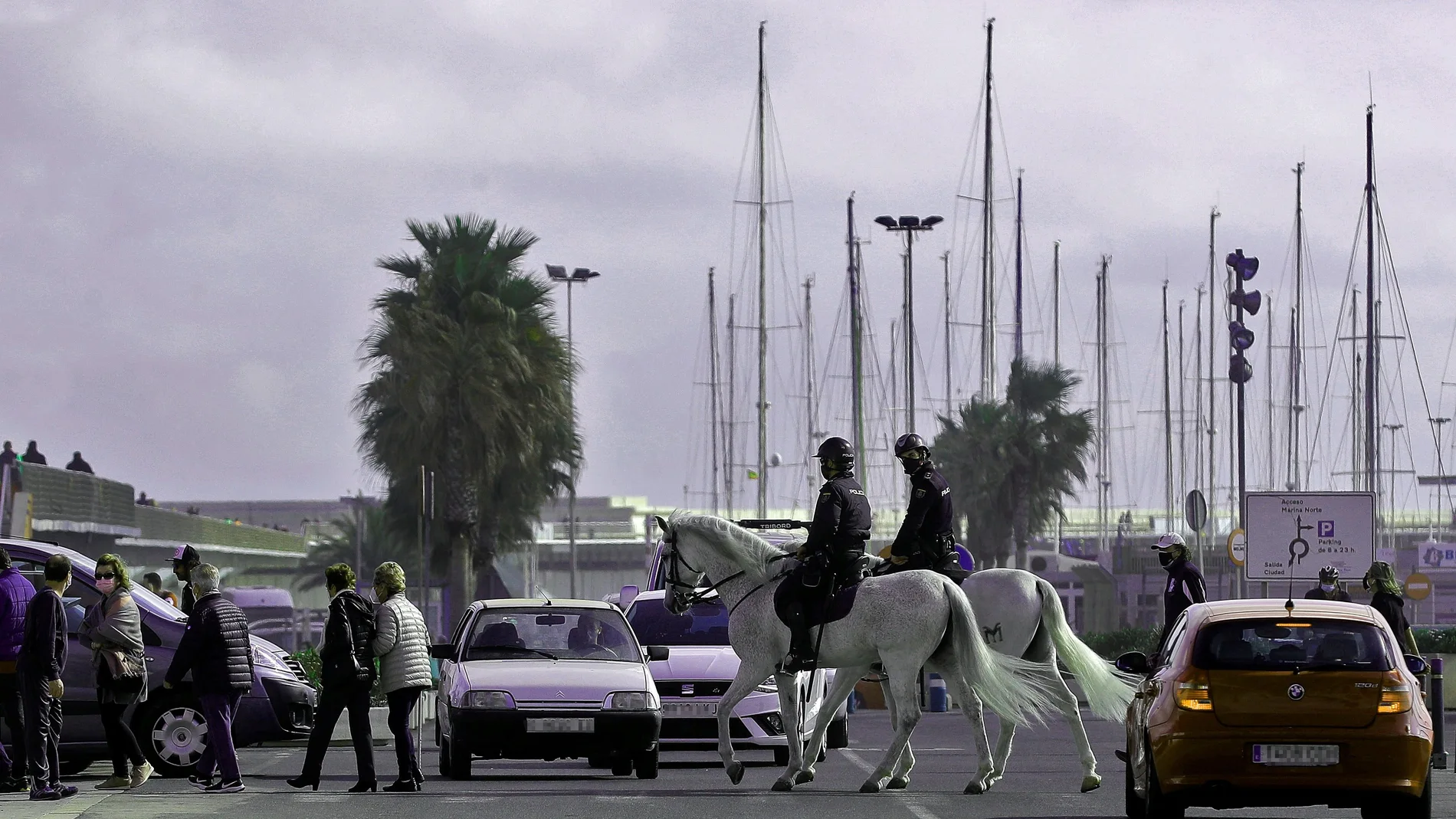 Dos agentes a caballo de la Policía Nacional patrullan este domingo en La Marina del Puerto de Valencia lugar al que, junto a las playas y el Jardín del Turia, acuden miles de valencianos para disfrutar del fin de semana durante el que la salida del municipio esta prohibida por el cierre perimetral impuesto a las poblaciones de más de 50.000 habitantes de la Comunitat Valenciana