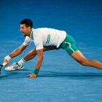 Djokovic, estirado para responder a una bola de Raonic en su partido de octavos de final del Open de Australia