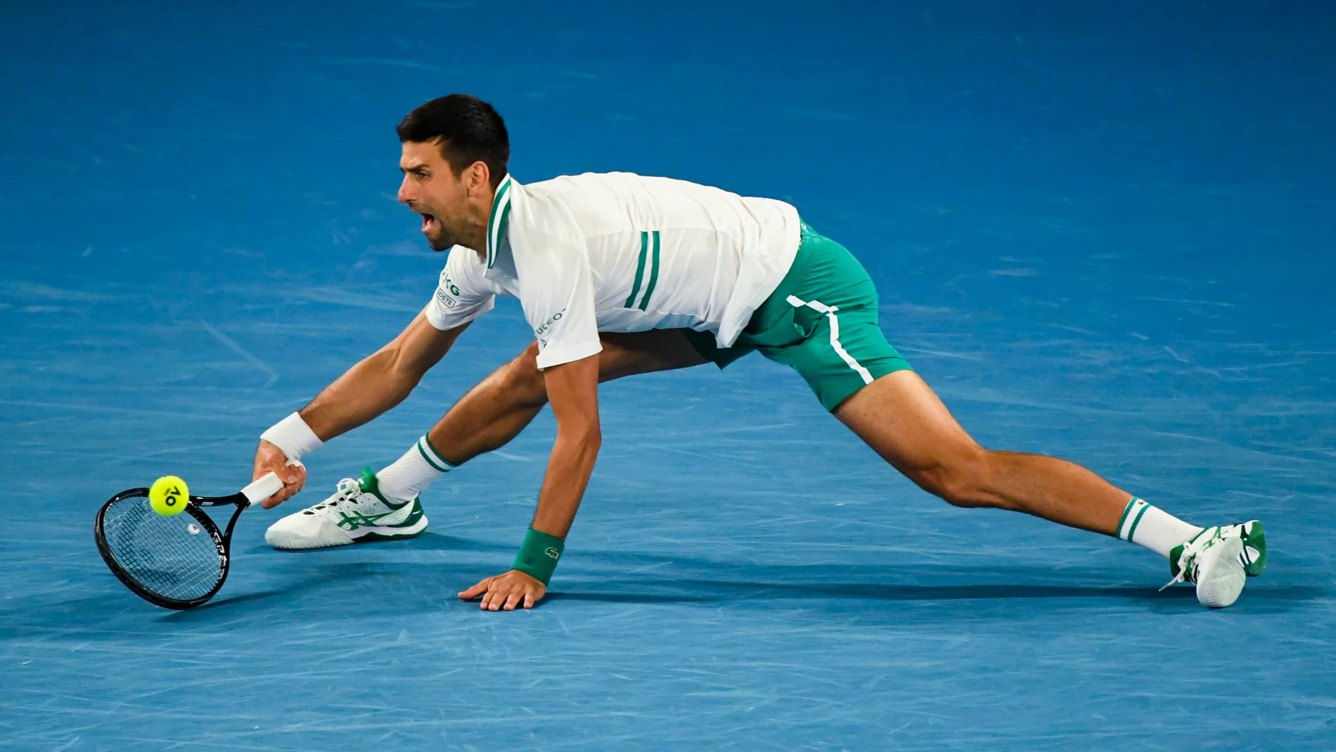 Djokovic, estirado para responder a una bola de Raonic en su partido de octavos de final del Open de Australia