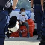 Un niño observa a varios policías en un campo de refugiados en la isla griega de Lesbos