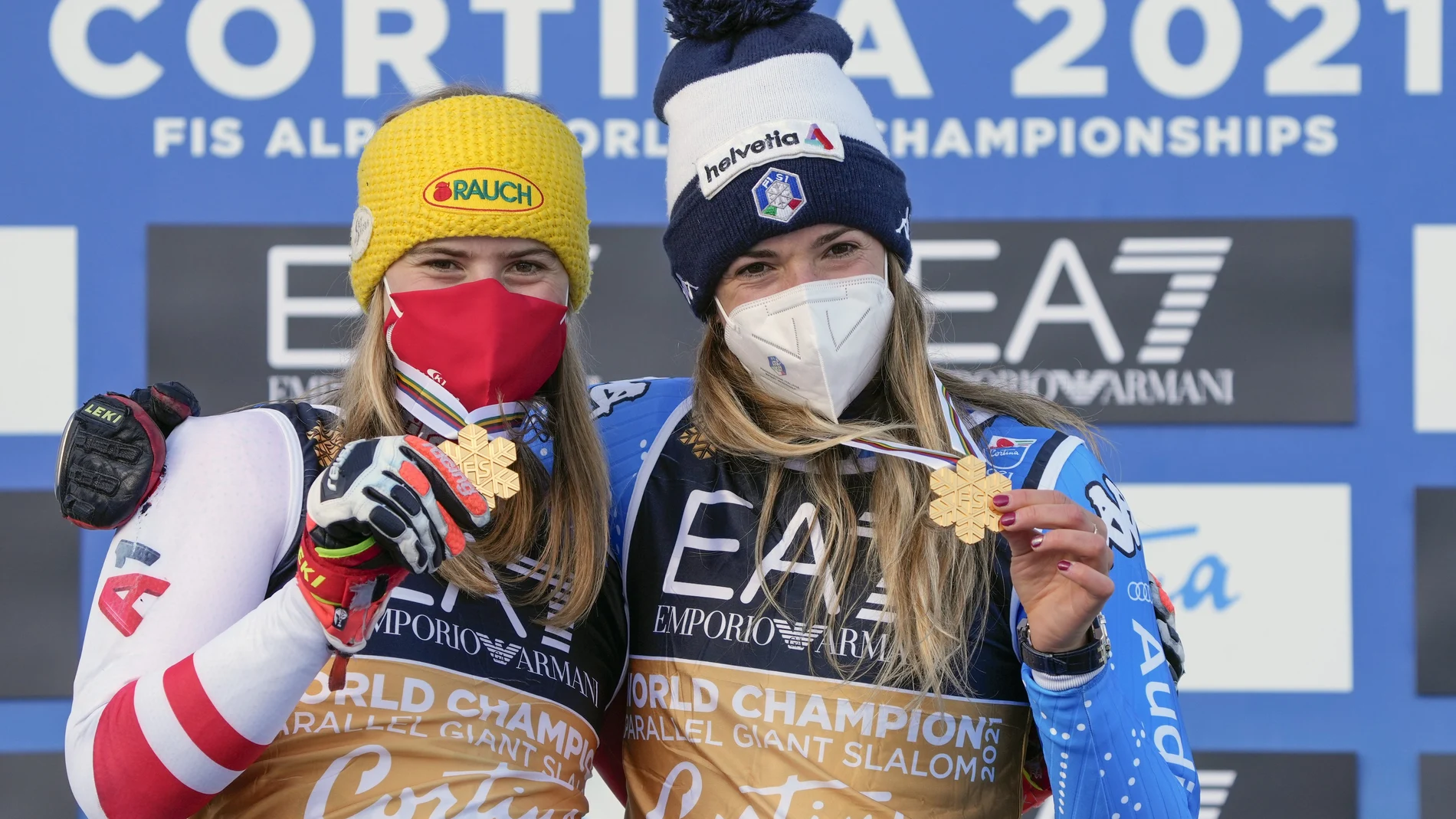 La italiana Marta Bassino, a la derecha, y la austriaca Katharina Liensberger muestran sus medallas de oro después del eslalon gigante paralelo, en los Campeonatos del Mundo de esquí alpino en Cortina d'Ampezzo, Italia, el martes 16 de febrero de 2021. La final femenina de dos carreras entre Marta Bassino y Katharina Liensberger terminó en un empate, y los organizadores declararon inicialmente a la italiana como ganadora y luego la plata de Katharina Liensberger se convirtió en un segundo oro. (AP Photo/Giovanni Auletta)