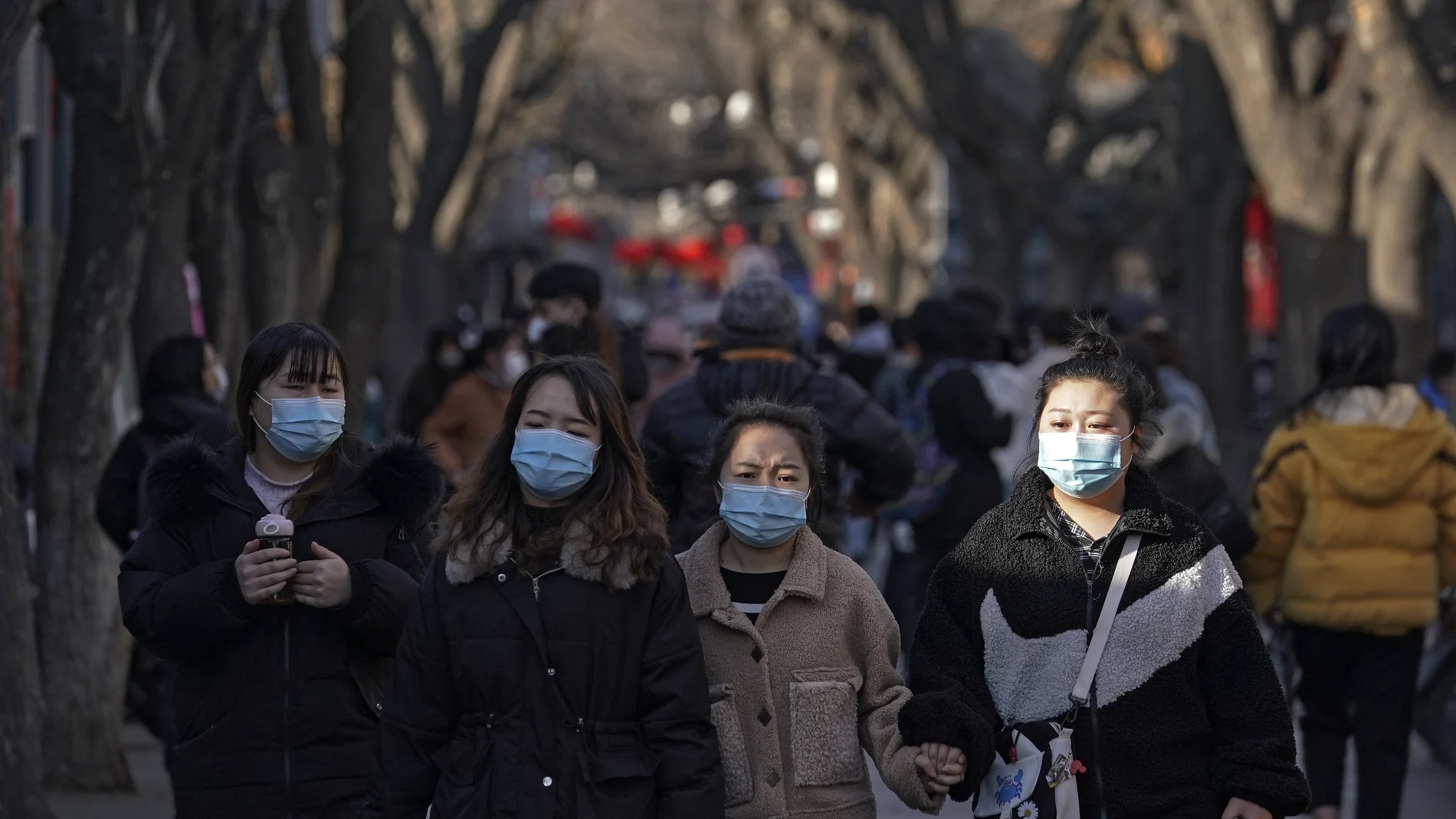 Visitors wearing face masks to help curb the spread of the coronavirus tour the Nanluoguxiang, the capital city's popular tourist spot on the fifth day of the Lunar Chinese New Year in Beijing, Tuesday, Feb. 16, 2021. (AP Photo/Andy Wong)