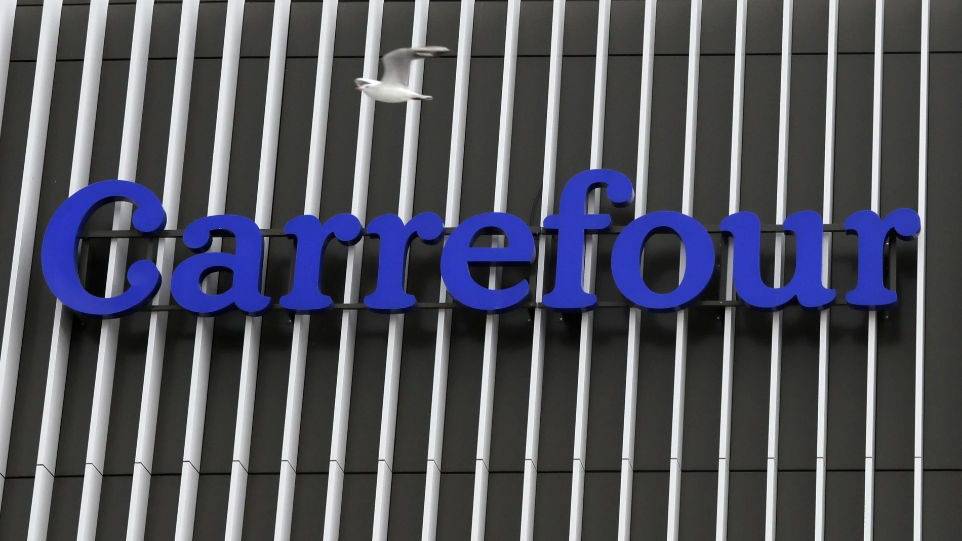 A seagul flies over the logo of Carrefour . February 17, 2021. REUTERS/Eric Gaillard
