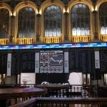 Una pantalla muestra información bursátil en el Palacio de la Bolsa en Madrid