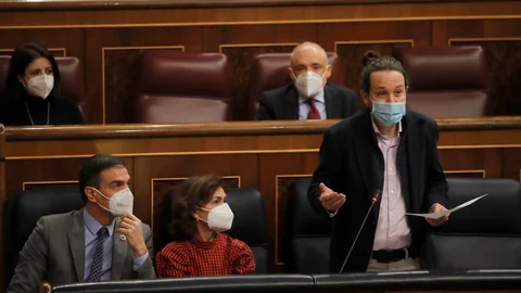 El vicepresidente segundo del Gobierno, Pablo Iglesias (d), habla en presencia del presidente del Gobierno, Pedro Sánchez (i), y la vicepresidenta primera, Carmen Calvo (c)