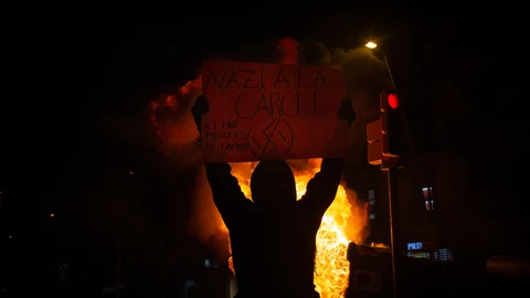 Uno de los manifestantes que apoyan a Pablo Hasel con una pancarta durante los disturbios en Barcelona (España), a 17 de febrero de 2021. David Zorrakino / Europa Press17/02/2021