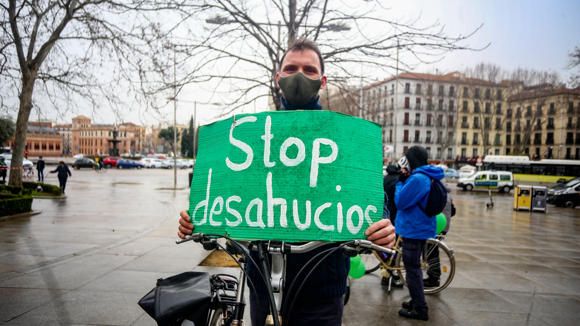 Un hombre con un cartel de "Stop desahucios" durante una manifestación por el derecho a la Vivienda en Atocha, a 21 de febrero de 2021