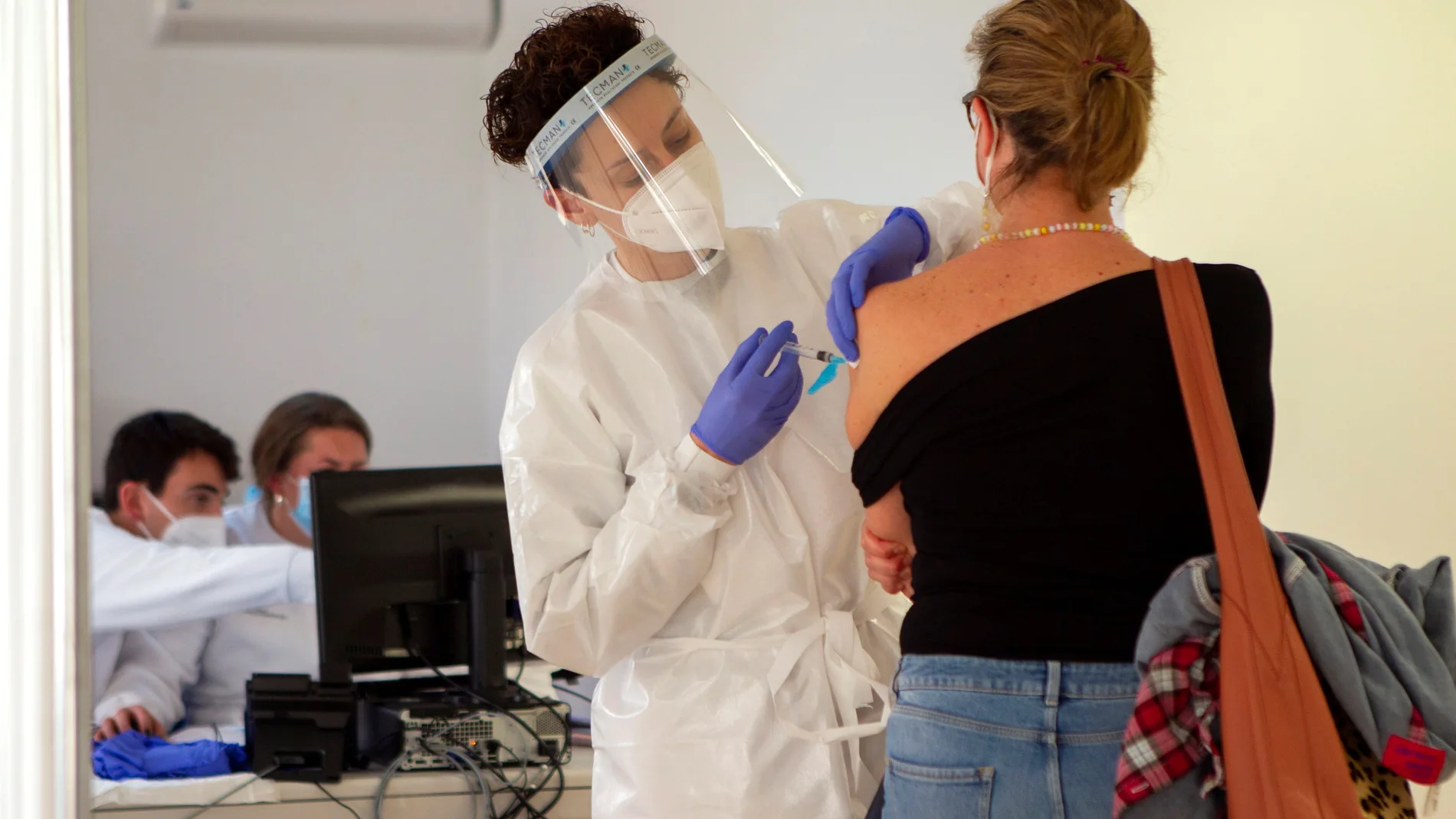 Personal sanitario vacuna a una mujer en el recinto del antiguo hospital Son Dureta, en Palma de Mallorca.