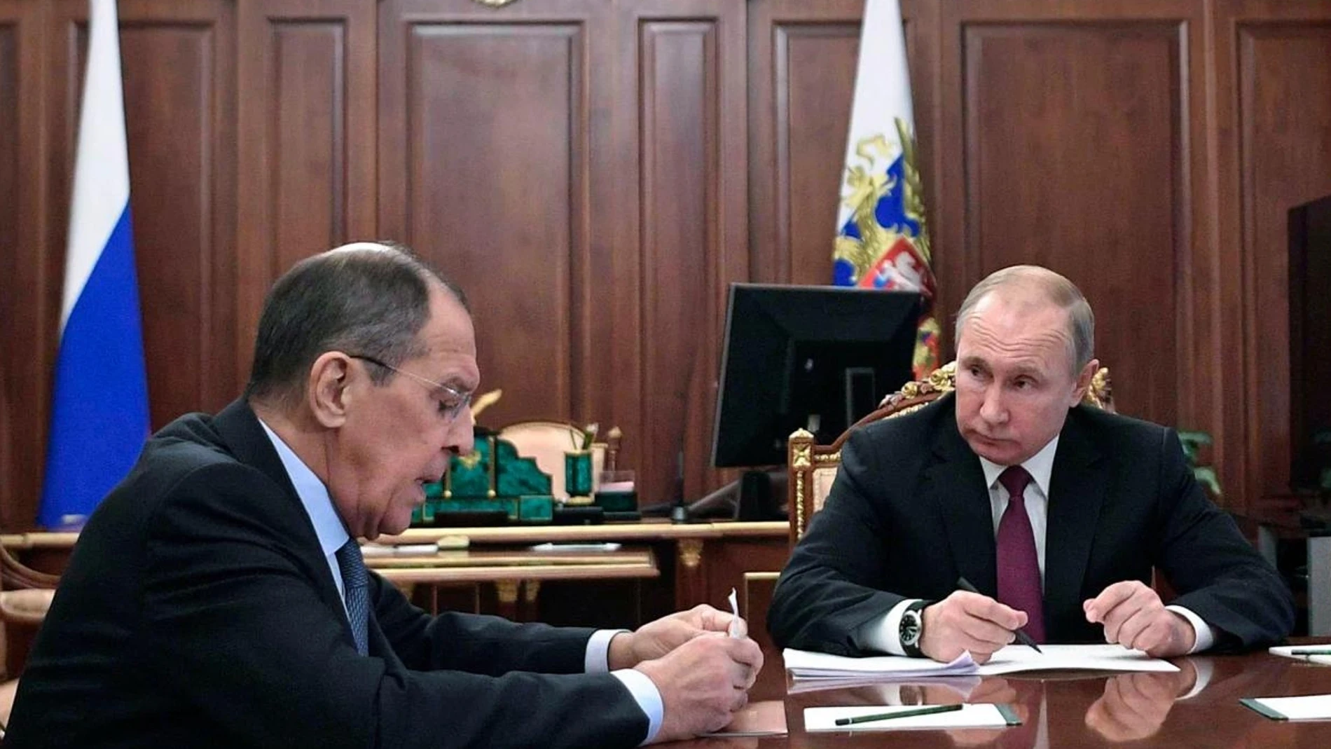 Vladimir Putin (C) durante una reunión que mantuvo con su ministro de Exteriores, Sergei Lavrov (L)