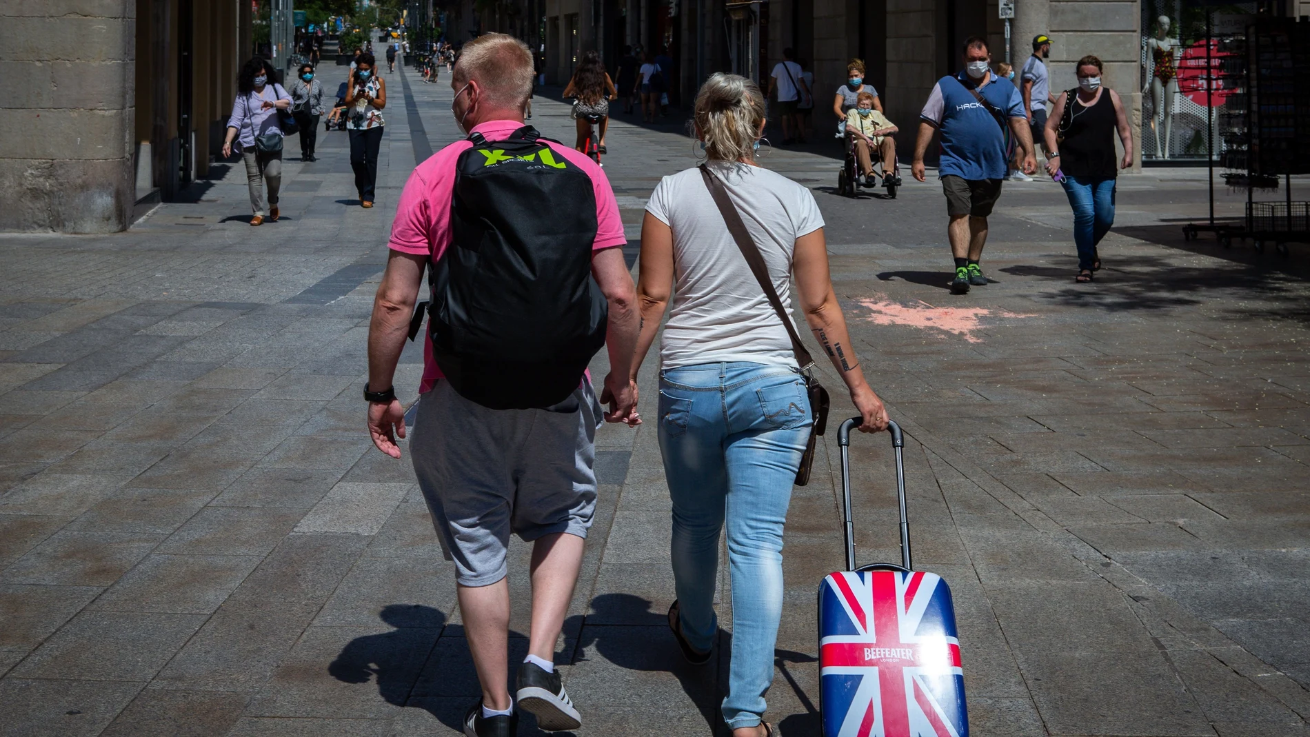Una pareja de turistas británicos caminan por el centro de Barcelona