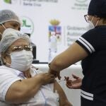 AME7977. SANTA CRUZ (BOLIVIA), 25/02/2021.- Una trabajadora de la salud recibe hoy la vacuna china Sinopharm contra la covid-19, en Santa Cruz (Bolivia). La vacuna china Sinopharm empezó a aplicarse este jueves en la ciudad de Santa Cruz, una de las más afectadas por la pandemia en Bolivia, entre la población de riesgo como enfermos de cáncer o con problemas renales y al resto del personal médico, ya que la mayoría de ellos ya fue inmunizada con la rusa Sputnik V. EFE/Juan Carlos Torrejón