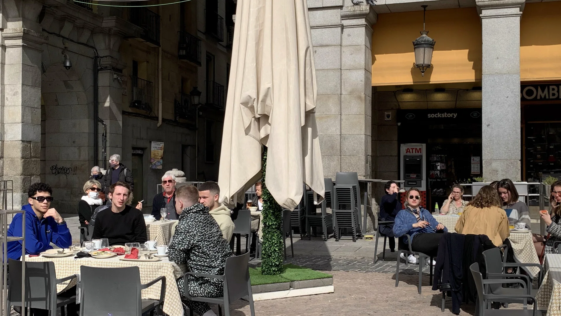 Turistas, en su mayoría franceses,disfrutan del sol en la Plaza Mayor de Madrid a finales de febrero