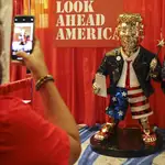 Una mujer se hace una foto con el Donald Trump dorado en el congreso conservador en Orlando, Florida