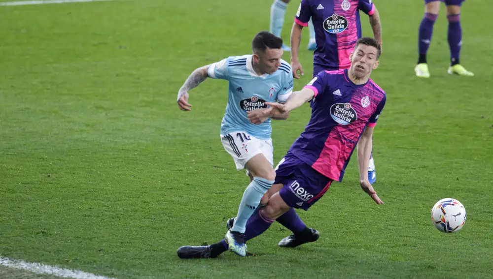 GRAF5576. VIGO (PONTEVEDRA), 28/02/2021.- El delantero del Celta de Vigo Iago Aspas (i), pugna por un balón, con el centrocampista del Valladolid Rubén Alcaraz en el partido de LaLiga disputado este domingo en el estadio Balaidos de Vigo. EFE / Salvador Sas