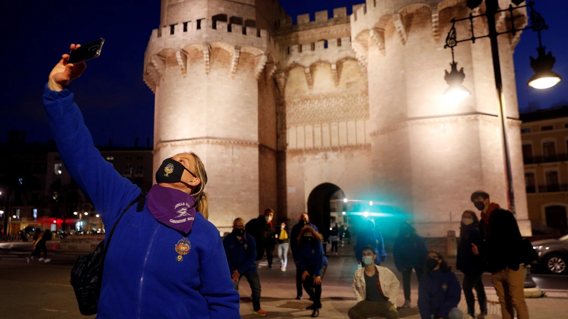 Miembros de la comisión fallera de Olivereta se hacen una foto ante las torres de Serranos la noche que se hubiese celebrado la Crida