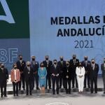 El presidente andaluz, Juanma Moreno, y la presidenta del Parlamento, Marta Bosquet, junto a los galardonados este 28F