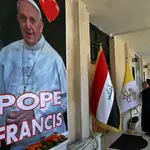 El padre Nazeer Dako arregla una bandera del Vaticano para recibir al Papa Francisco en la Iglesia Caldea de San José antes de la visita del Papa, en Bagdad