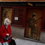 Una mujer pasa frente a una tienda de souvenirs cerrada en el centro de Madrid