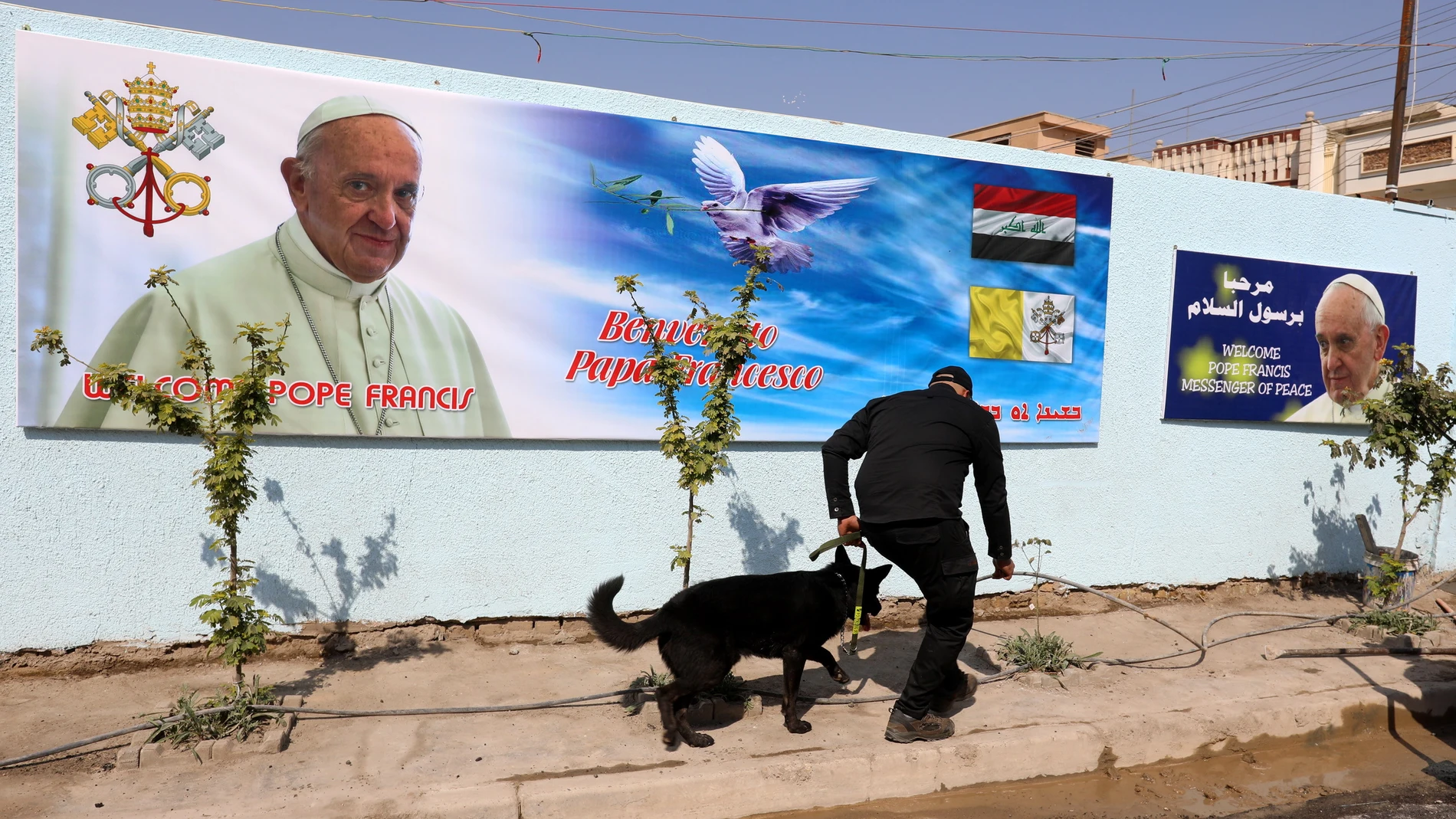 Un policía iraquí utiliza un perro para rastear la calle frente a la iglesia católica St. Joseph Chaldean en el distrito de Karada de Bagdad