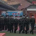 Policías paramilitares chino junto a una pancarta que representa al presidente chino Xi Jinping, no lejos de la sede del Congreso