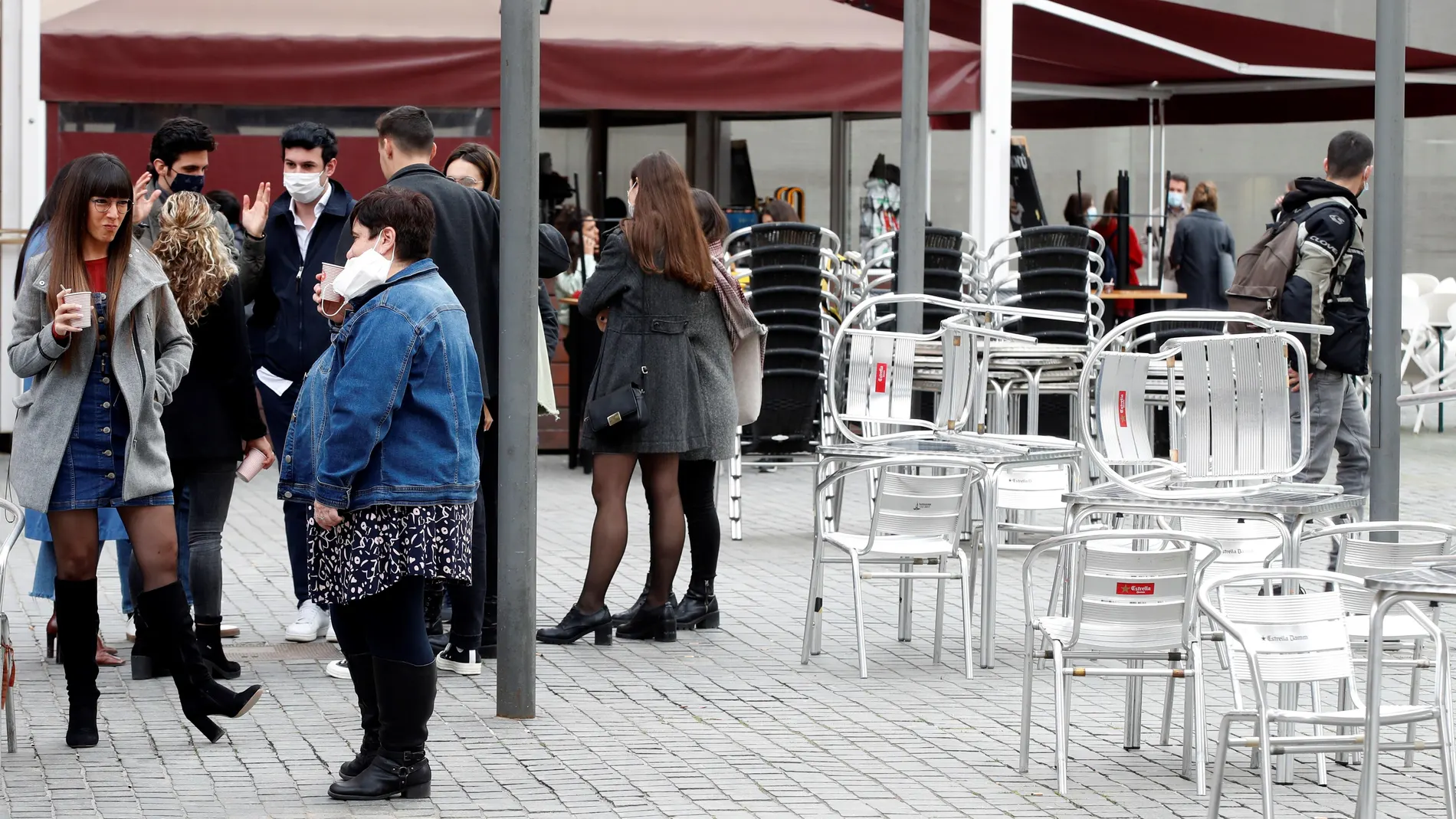 Varias personas consumen en la calle frente a las terrazas cerradas ubicadas en las inmediaciones de la Ciutat de la Justicia en L'Hospitalet de Llobregat