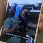 Un teléfono móvil muestra una foto de un hombre de Myanmar con una camiseta del ejército que amenaza con disparar contra los manifestantes antigolpistas