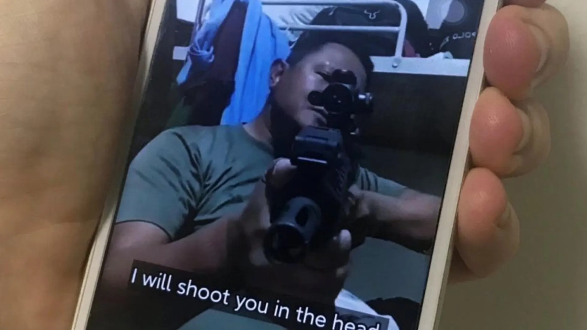 Un teléfono móvil muestra una foto de un hombre de Myanmar con una camiseta del ejército que amenaza con disparar contra los manifestantes antigolpistas