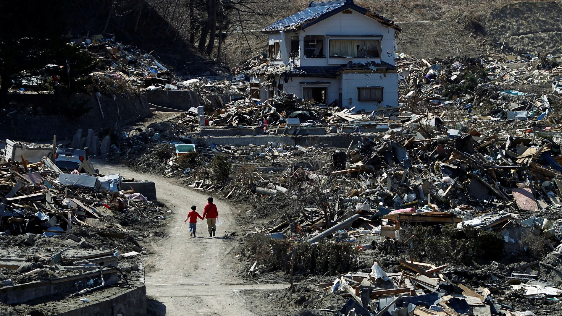 Dos personas pasean por un área devastada el 11 de marzo de 2011 por el terremoto y el posterior tsunami en la prefectura japonesa de Fukushima