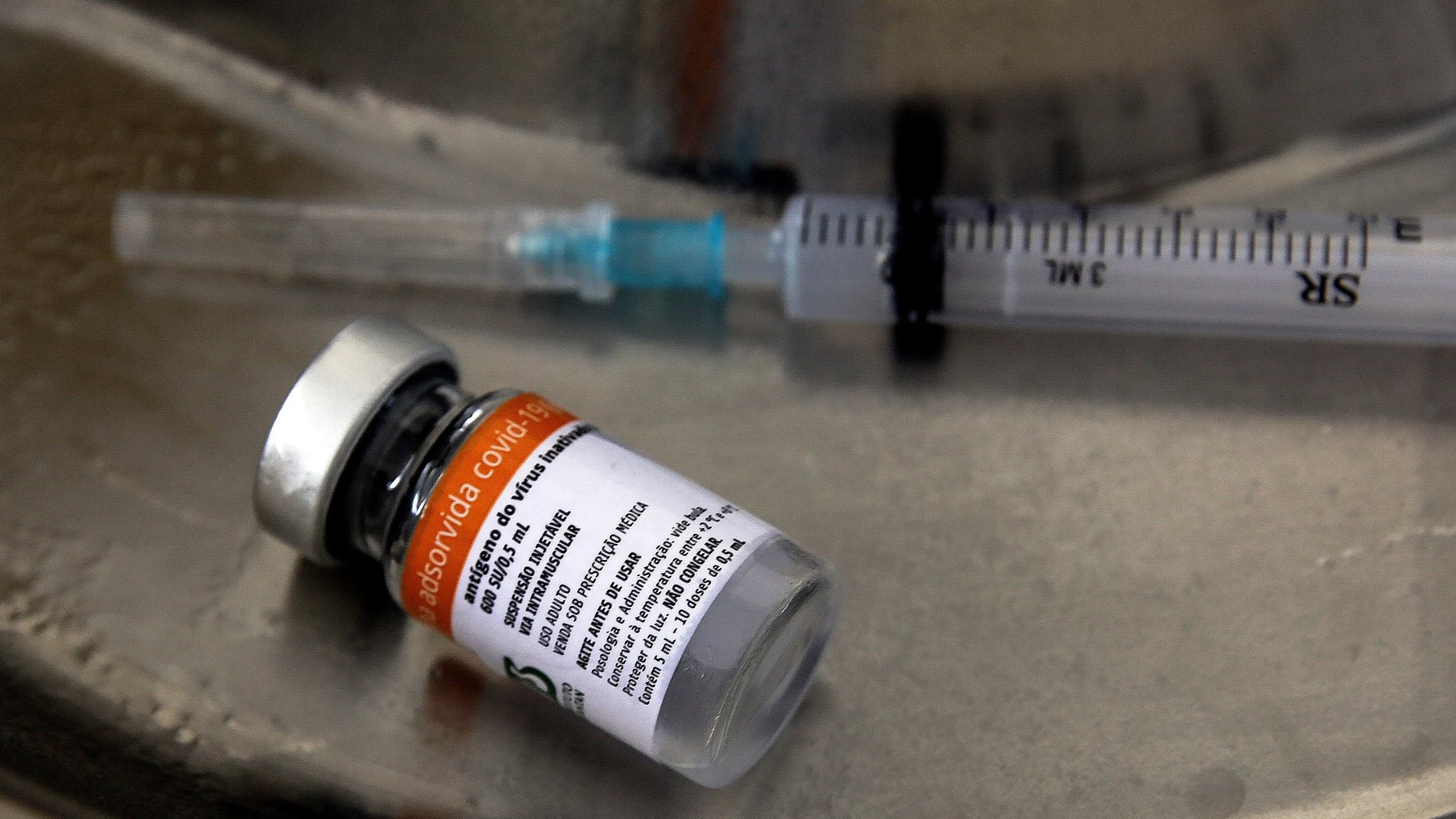 Fotografía de una jeringa junto a una dosis de la vacuna Coronavac contra la covid-19 durante una jornada de vacunación para adultos mayores