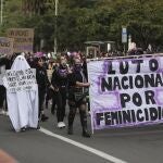 Activists march with a banner that reads in Spanish "National mourning because of femicides," during International Women's Day in Bogota, Colombia, Monday, March 8, 2021. (AP Photo/Fernando Vergara)