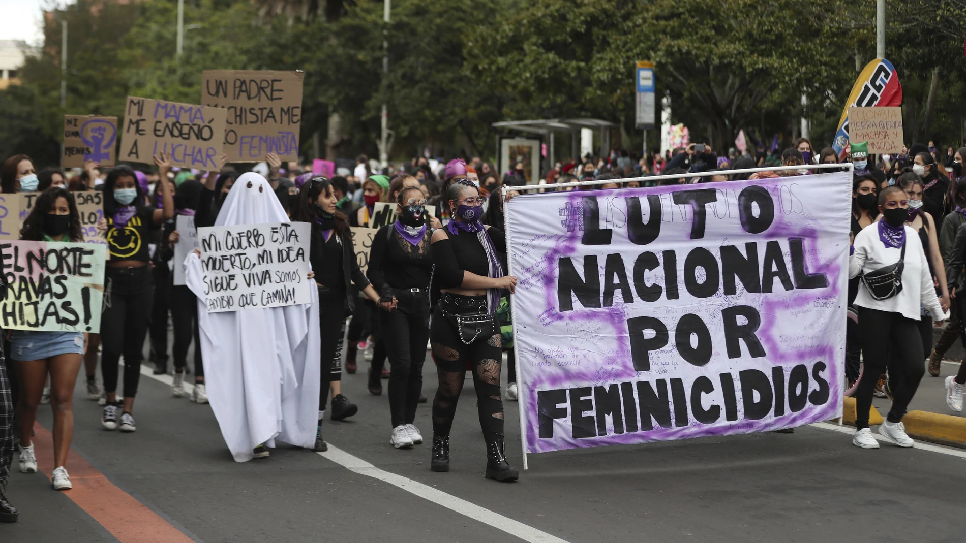 Activists march with a banner that reads in Spanish "National mourning because of femicides," during International Women's Day in Bogota, Colombia, Monday, March 8, 2021. (AP Photo/Fernando Vergara)