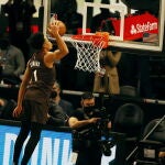 Anfernee Simons intenta besar la red de la canasta en su último mate.