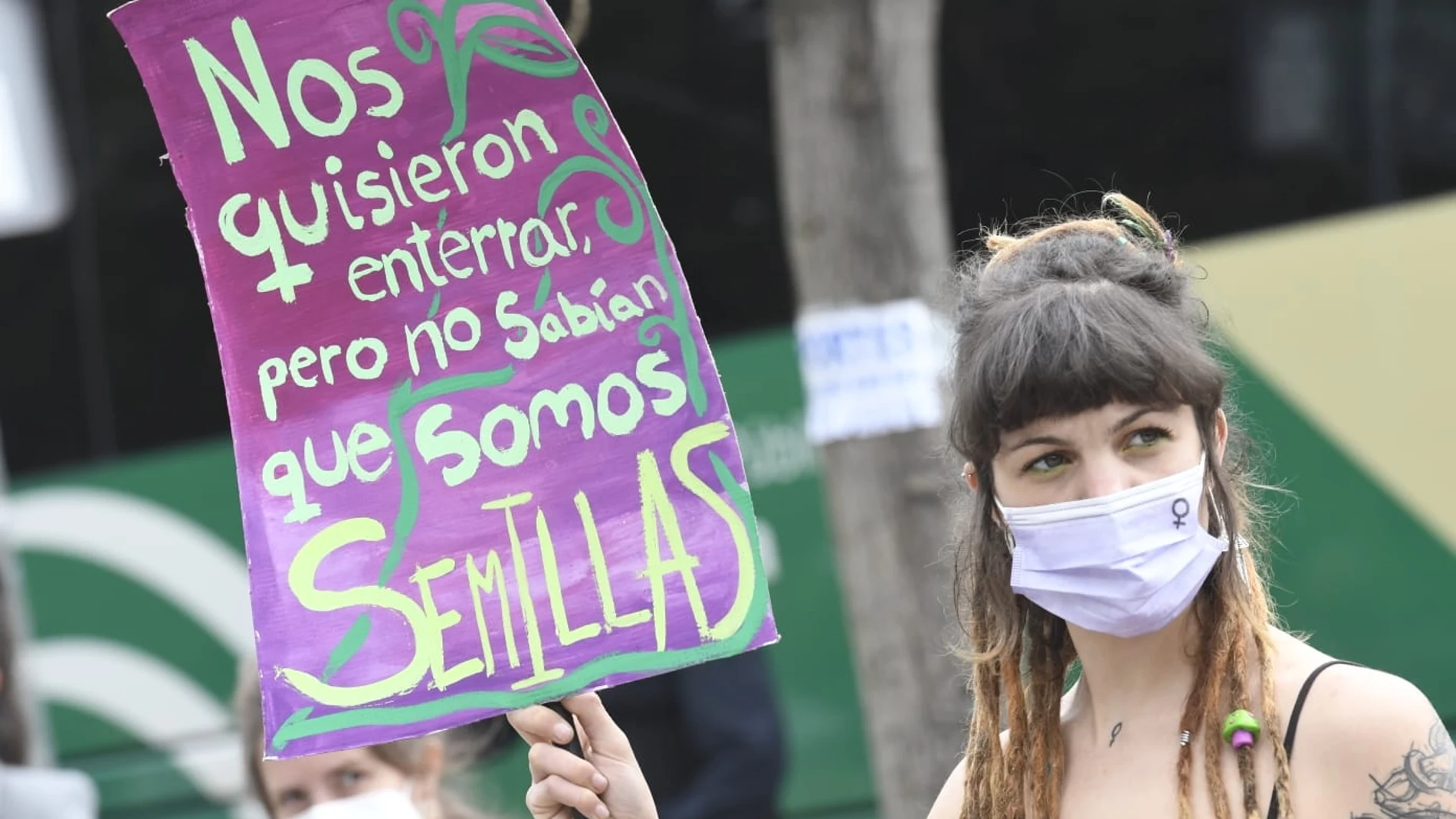 Una mujer sostiene una pancarta durante la concentración alrededor del Parlamento andaluz, con motivo del 8M