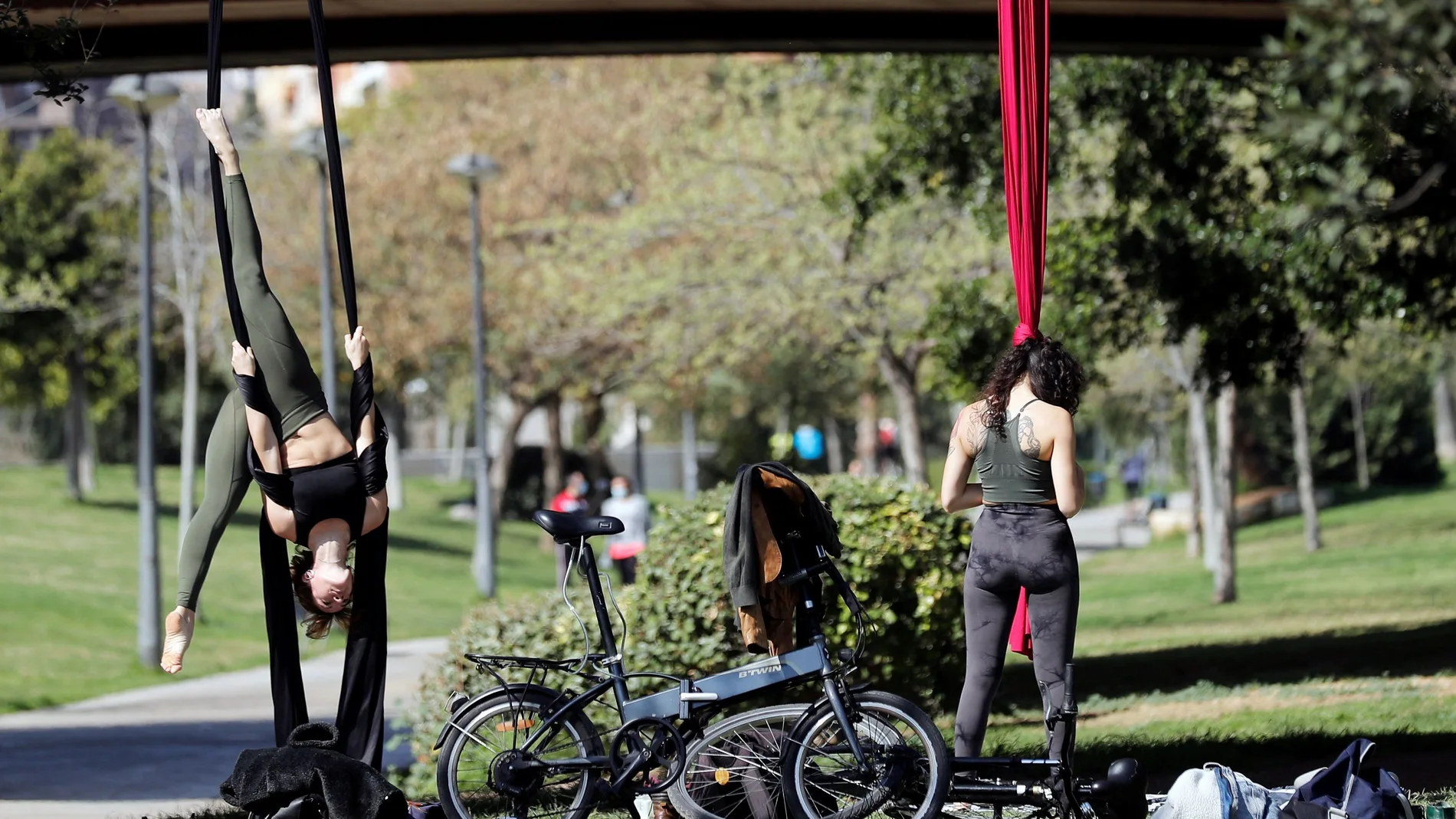 Dos personas realizan ejercicios al aire libre en los jardines del Turia