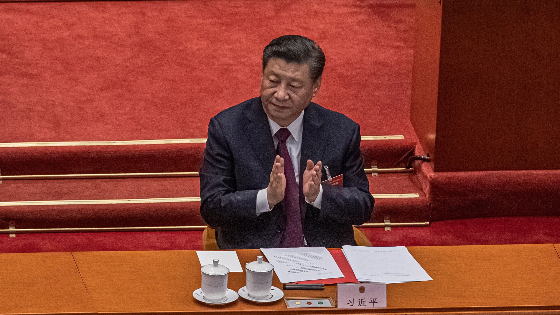 El presidente chino, Xi Jinping, aplaude tras votar una propuesta para redactar cambios en las reglas electorales para Hong Kong durante la sesión de clausura de la Asamblea Popular Nacional (APN)