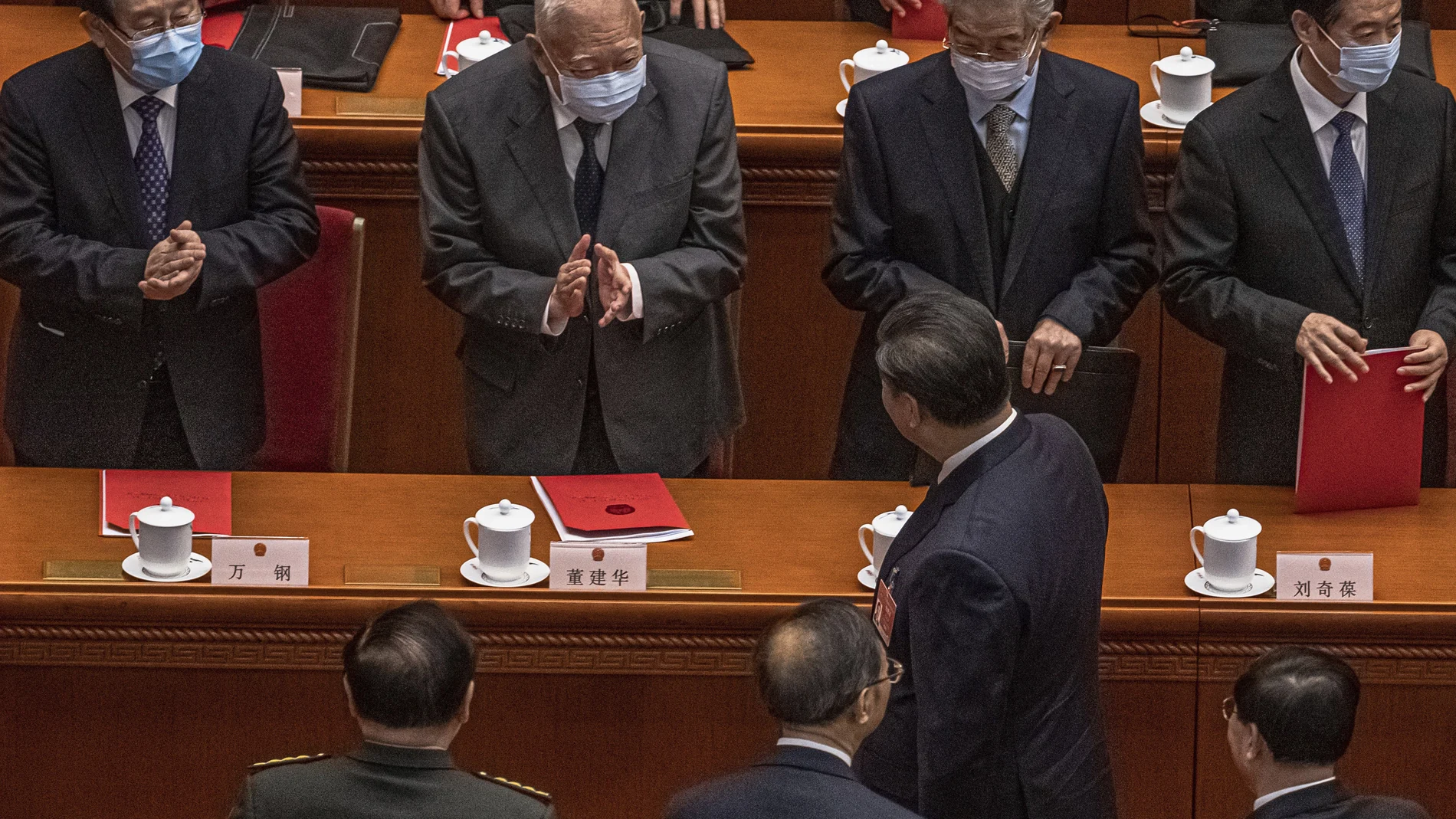 Former Hong Kong Chief Executive Tung Chee-hwa, second left top, claps to Chinese President Xi Jinping leaving after the closing session of the National People's Congress (NPC), at the Great Hall of the People, in Beijing, Thursday, March 11, 2021. Chinaâ€™s ceremonial legislature has endorsed the ruling Communist Partyâ€™s latest move to tighten control over Hong Kong by reducing the role of its public in picking the territoryâ€™s leaders. (Roman Pilipey/Pool Photo via AP)