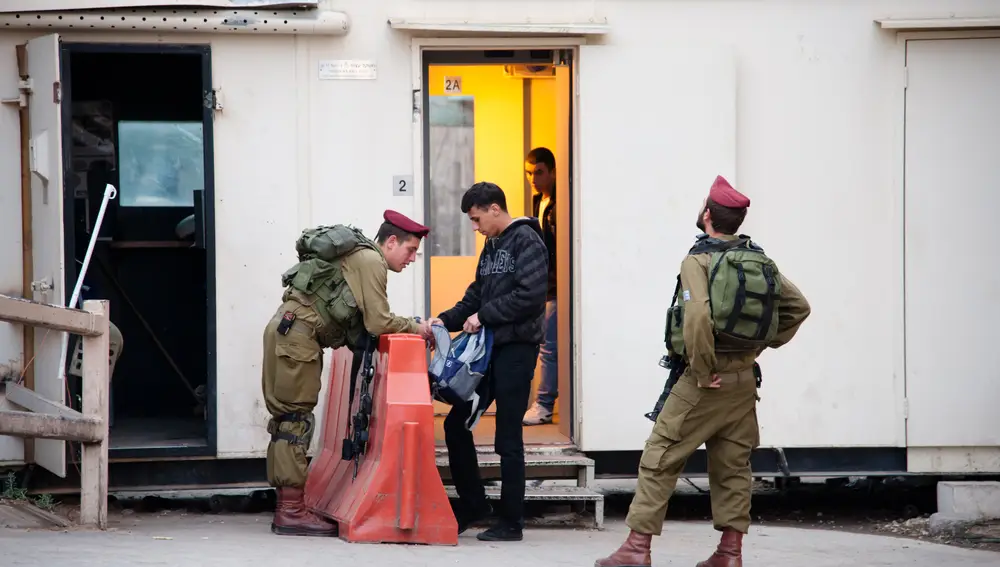 Soldados israelíes inspeccionan la mochila de un joven en uno de los puestos de control de la Tumba de los Patriarcas.