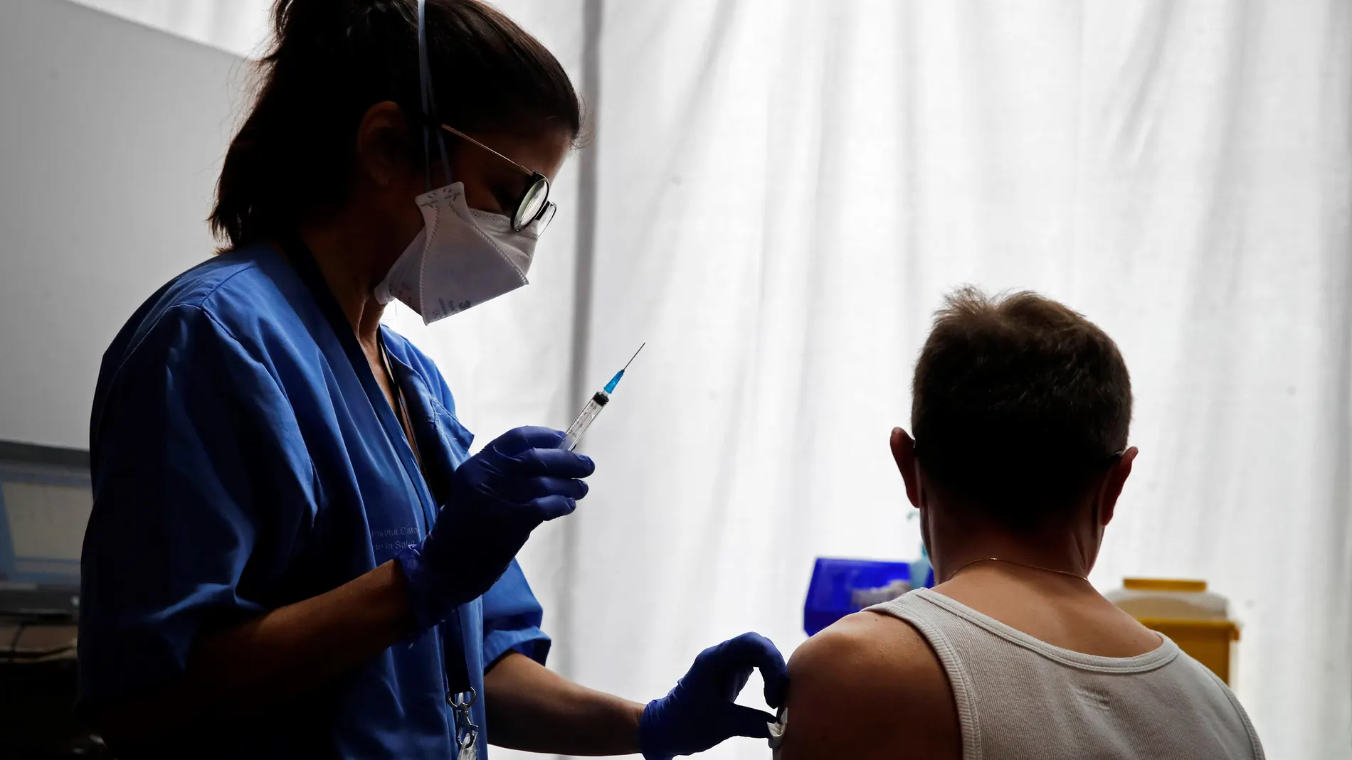 Una profesional sanitaria administra la vacuna contra la COVID-19 a un ciudadano en los pasillos del Hotel SB Plaza Europa, ubicado cerca del recinto de Fira de Barcelona de L'Hospitalet de Llobregat (Barcelona)