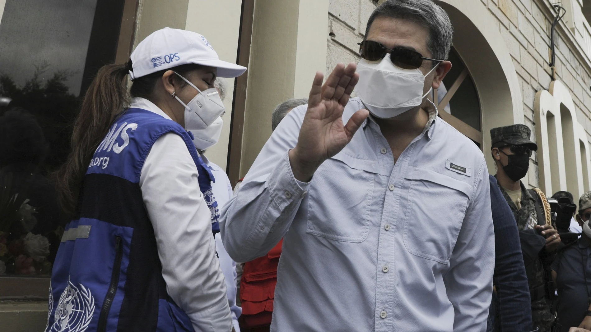 Honduran President Juan Orlando Hernandez waves upon his arrival to an air base to receive a shipment of the AstraZeneca COVID-19 vaccine via the COVAX program, in Tegucigalpa, Honduras, Saturday, March 13, 2021. (AP Photo/Elmer Martinez)