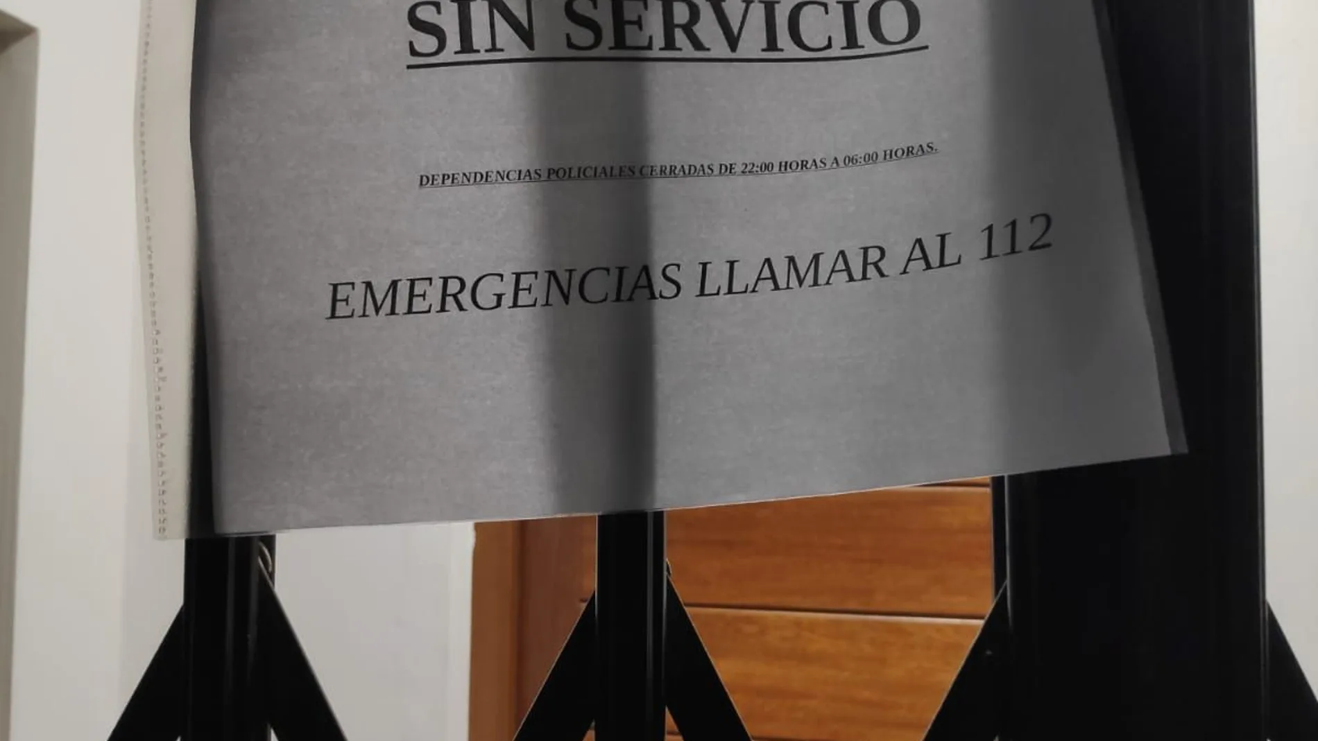 La puerta de la comisaría, cerrada, y con el cartel recomendando llamar al 112