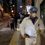 A worker wearing protective suit arrives at the locked-down part of the Sai Ying Pun area to contain a new outbreak of coronavirus disease (COVID-19), in Hong Kong, China March 15, 2021. REUTERS/Tyrone Siu