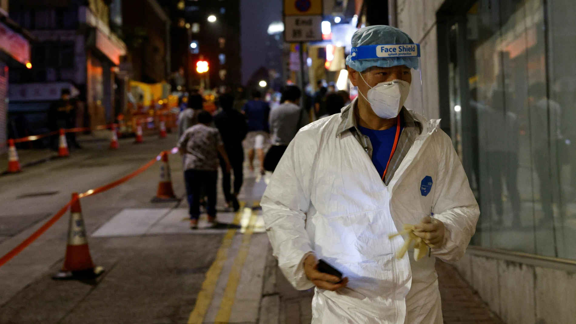 A worker wearing protective suit arrives at the locked-down part of the Sai Ying Pun area to contain a new outbreak of coronavirus disease (COVID-19), in Hong Kong, China March 15, 2021. REUTERS/Tyrone Siu