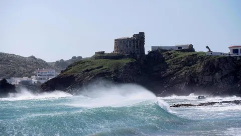 Imagen de archivo de unas olas chocan contra las rocas en una cala