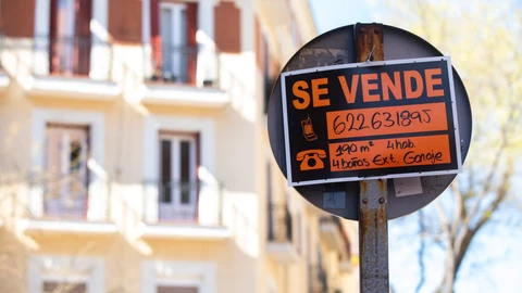 Cartel de se vende una vivienda en una señal de trafico