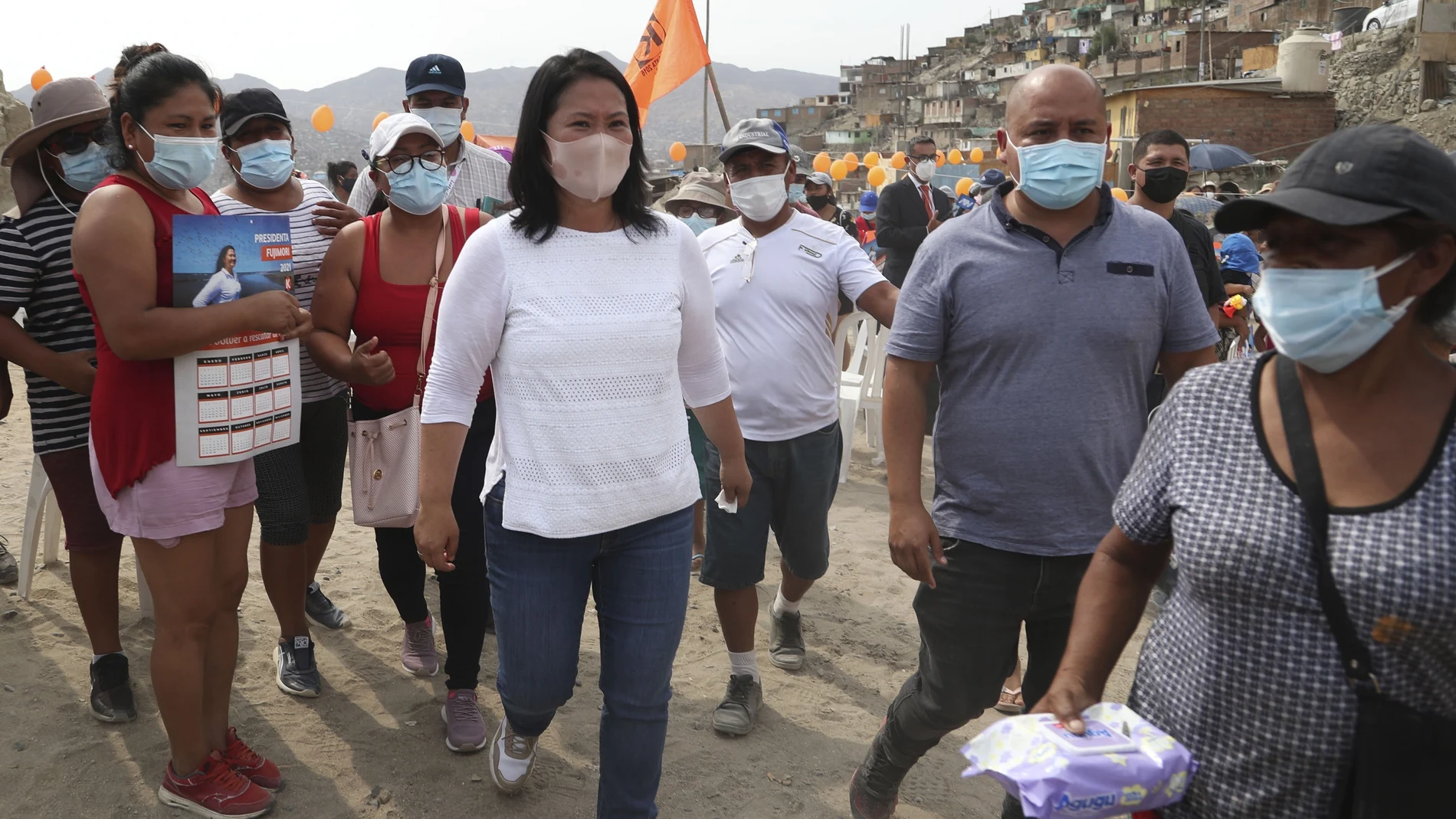 Wearing a mask to curb the spread of the new coronavirus, presidential candidate and daughter of imprisoned ex-President Alberto Fujimori, Keiko Fujimori, of the Popular Force party, campaigns in San Juan de Lurigancho on the outskirts of Lima, Peru, Tuesday, March 16, 2021. Peru's general election is set for April 11. (AP Photo/Martin Mejia)