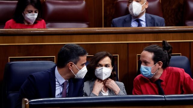 El presidente del Gobierno, Pedro Sánchez; su vicepresidenta primera, Carmen Calvo, y el todavía vicepresidente segundo, Pablo Iglesias, conversan durante la nueva sesión de control al Gobierno